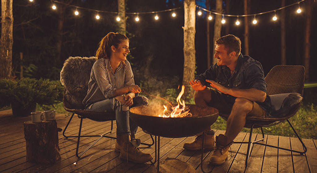 Couple Sitting by Fire Outdoors